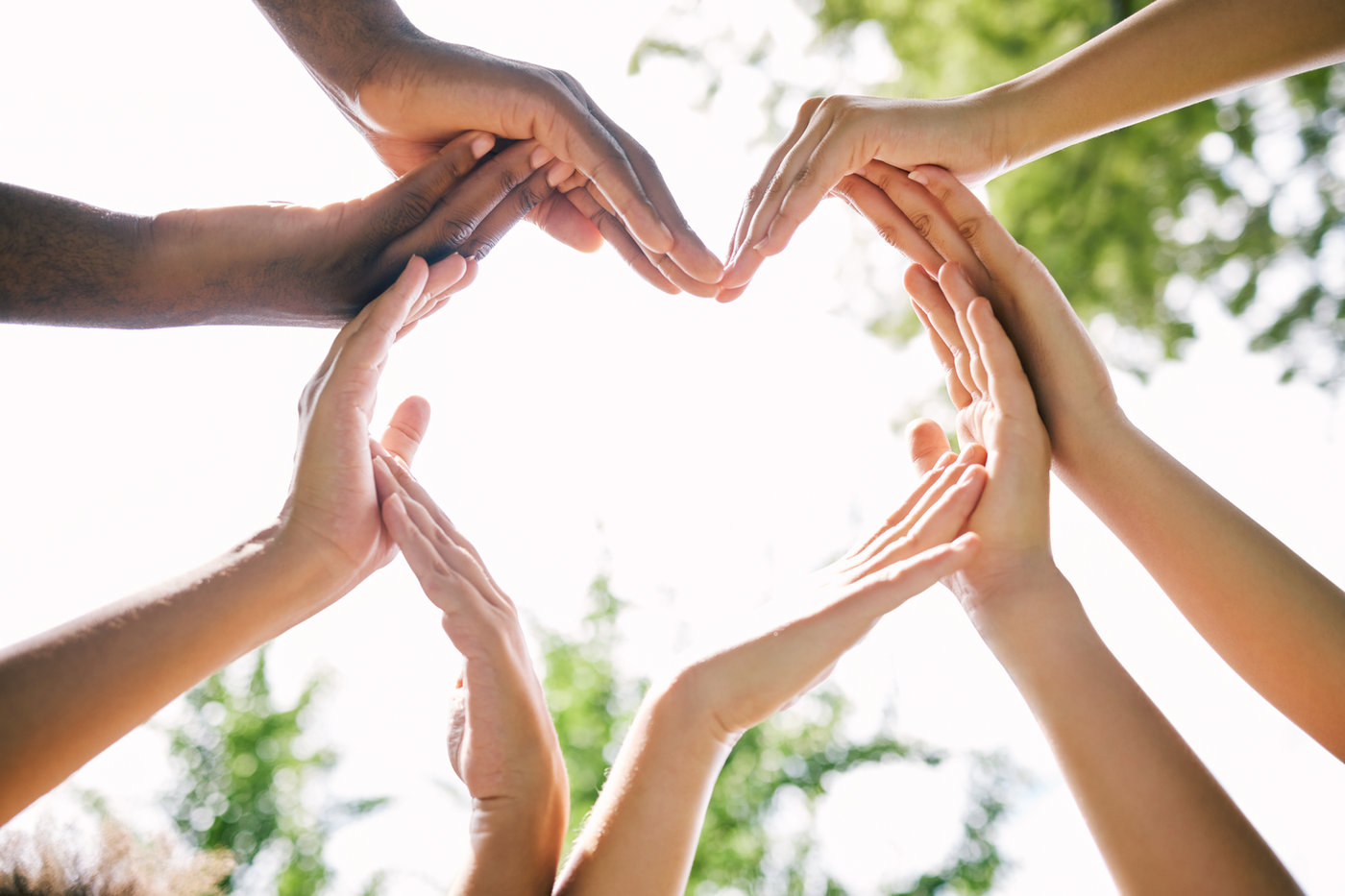 People joining hands in a heart shape